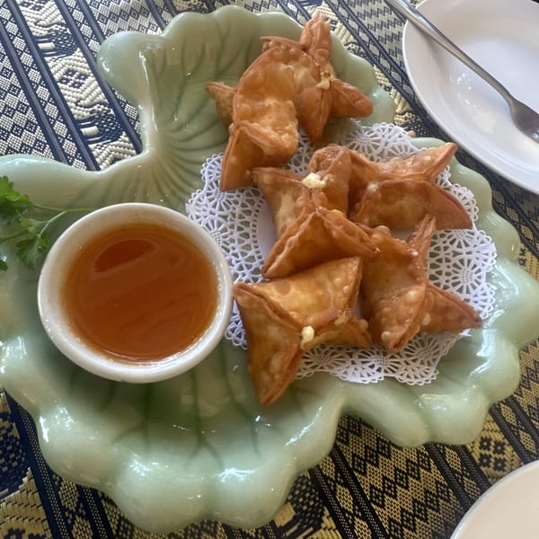 Crab rangoons with sweet chili dipping sauce on a leaf-shaped plate at Thai Palace & Sushi Bar.