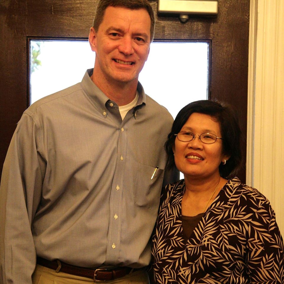 A smiling man and woman, likely the owners of Thai Palace & Sushi Bar, stand together.