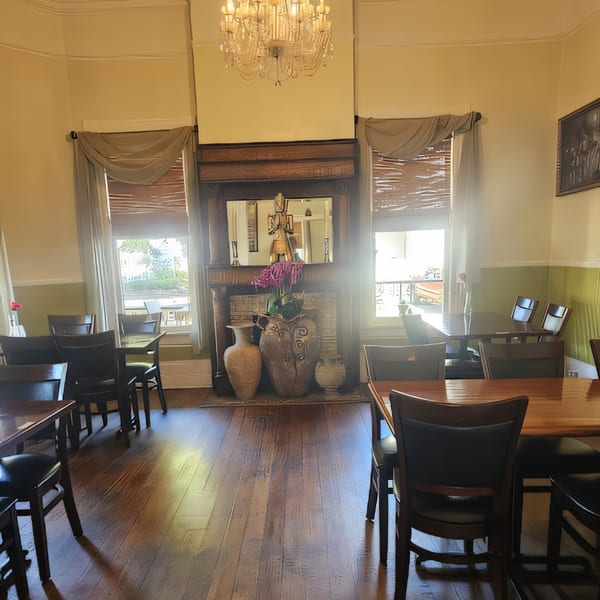Dining room at Thai Palace & Sushi Bar with tables, chairs, and a decorative fireplace.