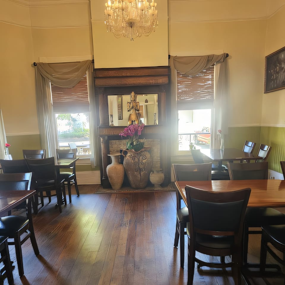 Dining room at Thai Palace & Sushi Bar with tables, chairs, and a decorative fireplace.