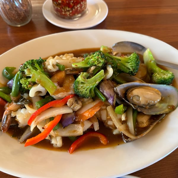 Thai seafood stir-fry with broccoli, bell peppers, and mussels in a rich brown sauce.